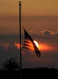 Flag Flying at half staff in the setting sun